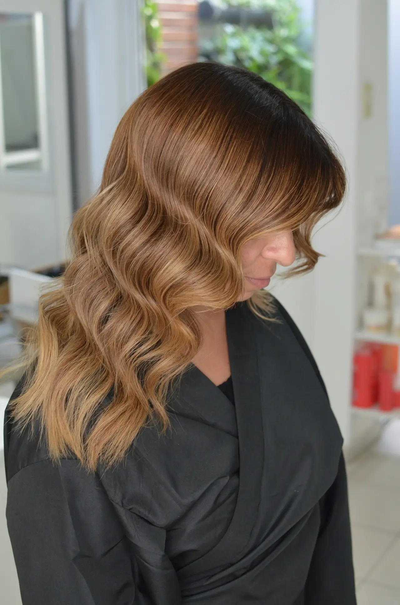 Melena castaña con ondas suaves y reflejos caramelo